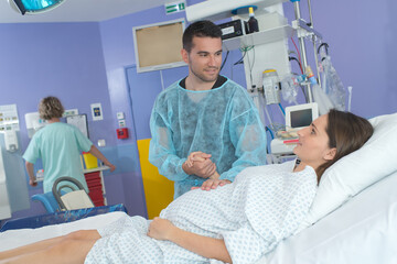 woman having contraction giving birth in hospital with husband