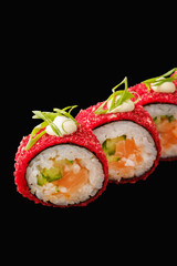 japanese sushi roll with salmon, japanese mayonnaise, chili sauce, rice balls, green onion, cucumber, chili pepper. isolated on black background. Close up