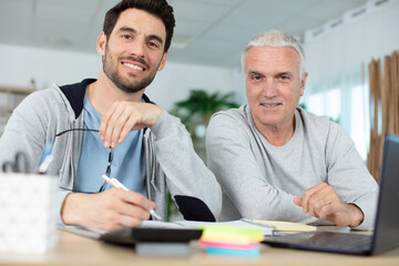 Obraz premium adult son with senior father at home accounting