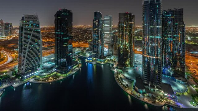 Tall residential buildings at JLT aerial all night timelapse, part of the Dubai multi commodities centre mixed-use district.