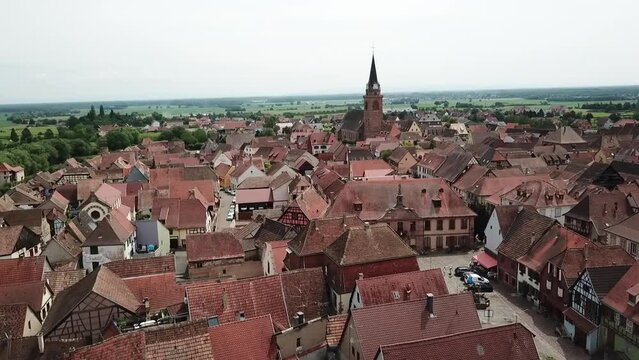A stationary 360 panning footage to the right while revealing the grassland, some crops and the whole village. This is located at the fortified village of Bergheim, Haut-Rhin. You can see the horizon.