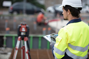 surveyor on site making notes on clipboard