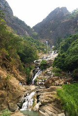 Fototapeta na wymiar Ravana Falls waterfall near Ella, Sri Lanka (Translation of writing on rock: Do not climb on rocks, slippery)