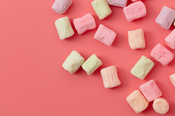 Multicolored candies on a pink background. Close-up