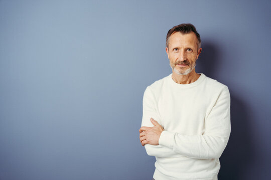 bestager stands in front of a blue wall and looks into the camera, copy space