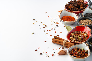 Bowls with various spices on white background