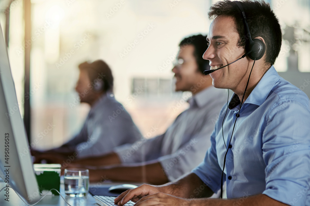 Poster Committed to quality customer support. Cropped shot of a call centre agent working in an office with his colleagues in the background.