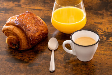 breakfast with croissant, coffee and orange juice on wooden table