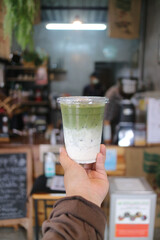 Matcha, green tea - Barista pouring Matcha to a glass of ice with traditional japanese matcha tools