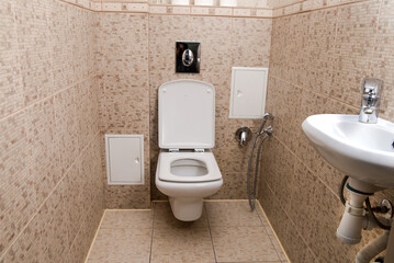 Toilet room interior with white toilet bowl. Lid is open.