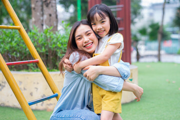 Asian mother and daughter playing together at park