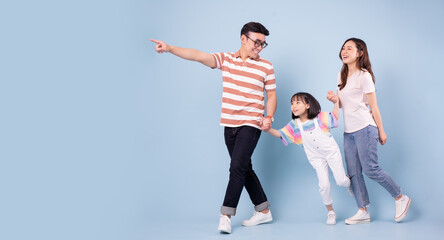 Full length image of young Asian family on background