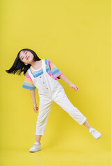Fototapeta na wymiar Full length image of Asian child posing on yellow background