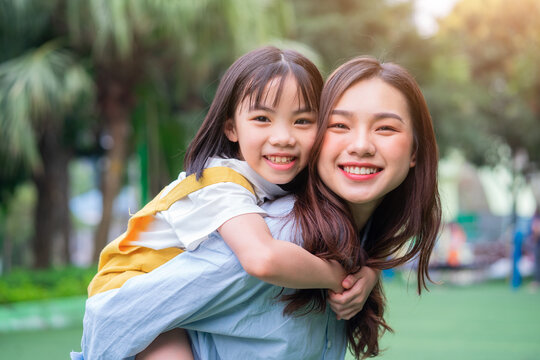 Asian mother and daughter playing together at park
