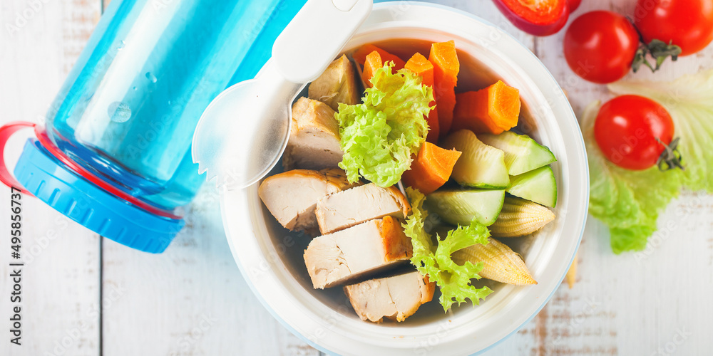 Wall mural healthy break - meat and vegetables in a lunchbox on a light wooden background. selective focus. cop