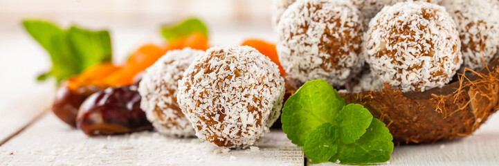 Homemade dietary candies from dates and an apricot in coconut topping. Selective focus. Copy space