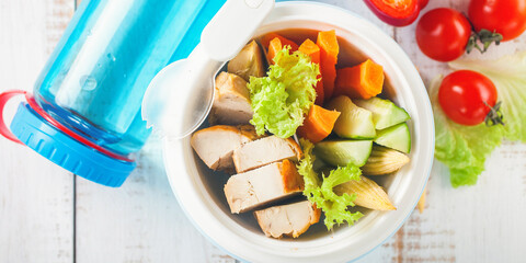 Healthy break - meat and vegetables in a lunchbox on a light wooden background. Selective focus. Copy space, Top view