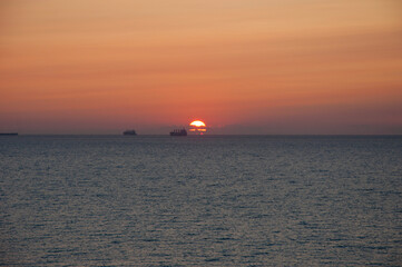 sunset sky and sea with ship on horizon, summer holiday