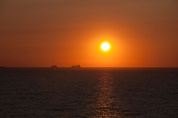 sundown sky and sea with ship on horizon, bora bora