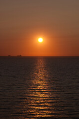 Fototapeta na wymiar sunrise sun and seascape with ship on horizon, summer