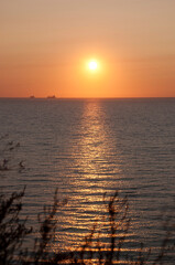 Naklejka premium sunrise sun and seascape with boat on horizon, summer