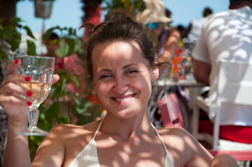 happy young woman drink wine in summer restaurant on vacation resort