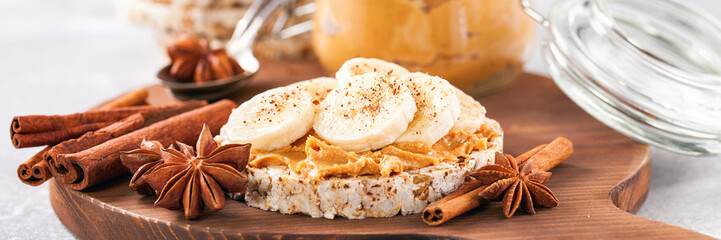 Crisp bread with peanut butter and bananas on a board. Selective focus. Copy space