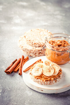 Crisp bread with peanut butter and bananas on a board. Selective focus. Copy space. Image is tinted
