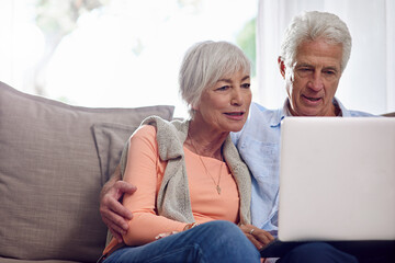 Spending some online boo. Shot of a senior couple using a laptop at home.