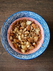 large vertical photo. homemade food. spelled groats boiled with banana slices and almonds in a round ceramic plate with a pattern. useful vitamin breakfast. eco. bio. diet food
