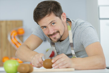 a young man is cutting tomatoes