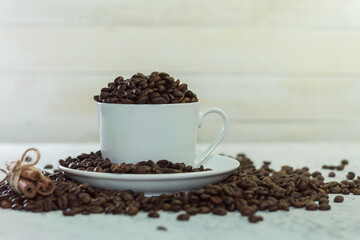 White cup and saucer with fragrant coffee beans