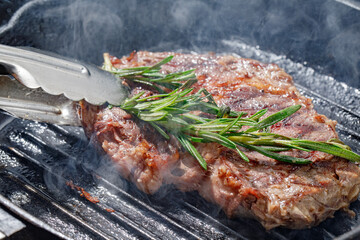 Premium dry-aged rib-eye steak grilling on a kamado grill. Dry-aged raw meat steak grilling and...