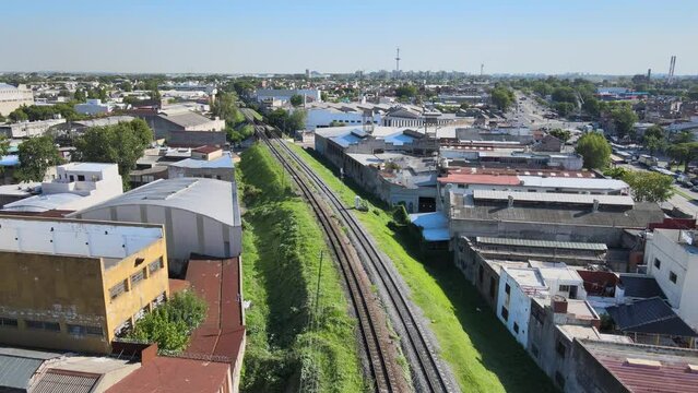 Aerial view following the train tracks with surrounding buildings