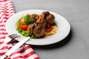 Cooked meat with fresh vegetable salad on a white plate