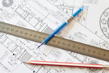 Pen, pencil and ruler lying on the drawing lying on the table of the design service. Industrial engineer workplace