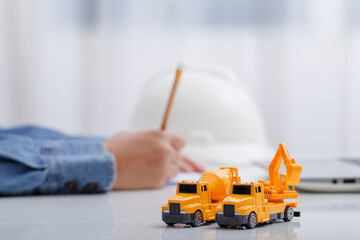 Concrete mixer truck and excavator on architect's desk, Engineering objects, Construction site.