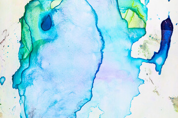 Abstract expansion of blue, purple and green colors of watercolor.