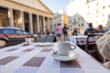 Coffee cup on a table at traditional cafe in Rome city. Concept of italian coffee and travel