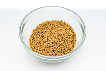 Fenugreek seeds - Methi dana closeup over isolated white