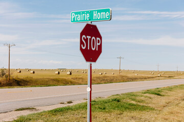 Prairie Home sign and stop sign at the side of a road. 