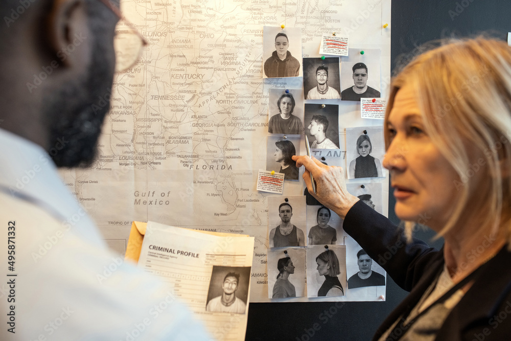 Aufkleber blond confident female detective pointing at photo of suspect on board over map while matching facts