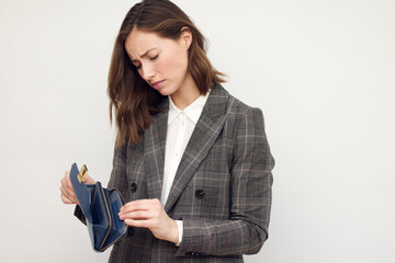 Young beautiful business woman over white background holding an empty wallet looking sad. Isolated on white. Concept: No money - what to do? - obrazy, fototapety, plakaty
