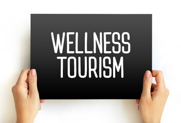 Wellness tourism - travel for the purpose of promoting health and well-being through physical, psychological, or spiritual activities, text on card concept