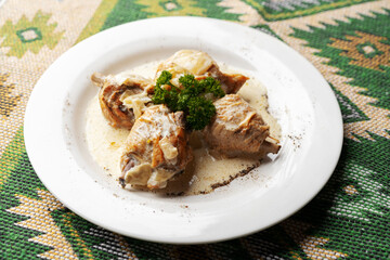Chicken stewed in a creamy sauce on white plate