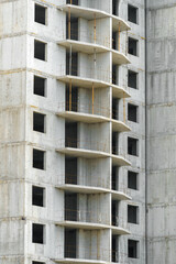 construction of a modern high-rise building, the creation of a concrete frame, building materials and a construction crane