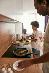 Fototapeta na wymiar African family cooking breakfast at home kitchen