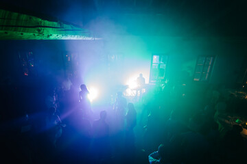 Silhouette image of people dance at wedding party by night. New year night party and nightlife concept.