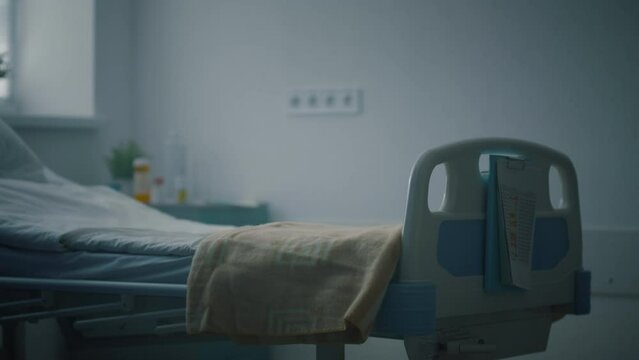 Closeup empty hospital bed with medical records attached in intensive care unit.