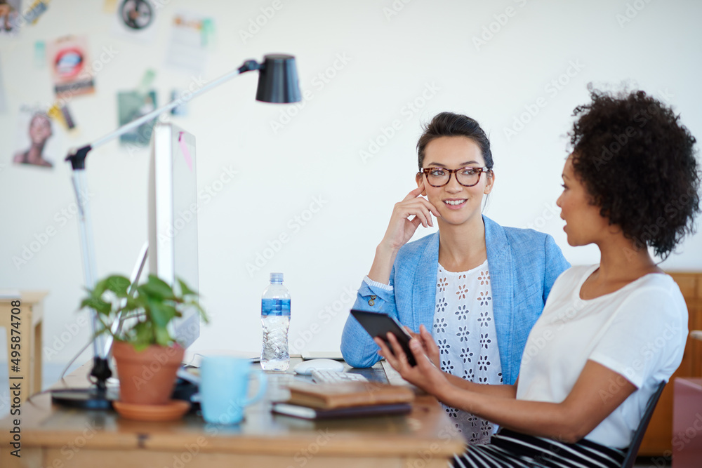 Poster shot of an attractive young woman sitting at her workstation in the office. the commercial designs d